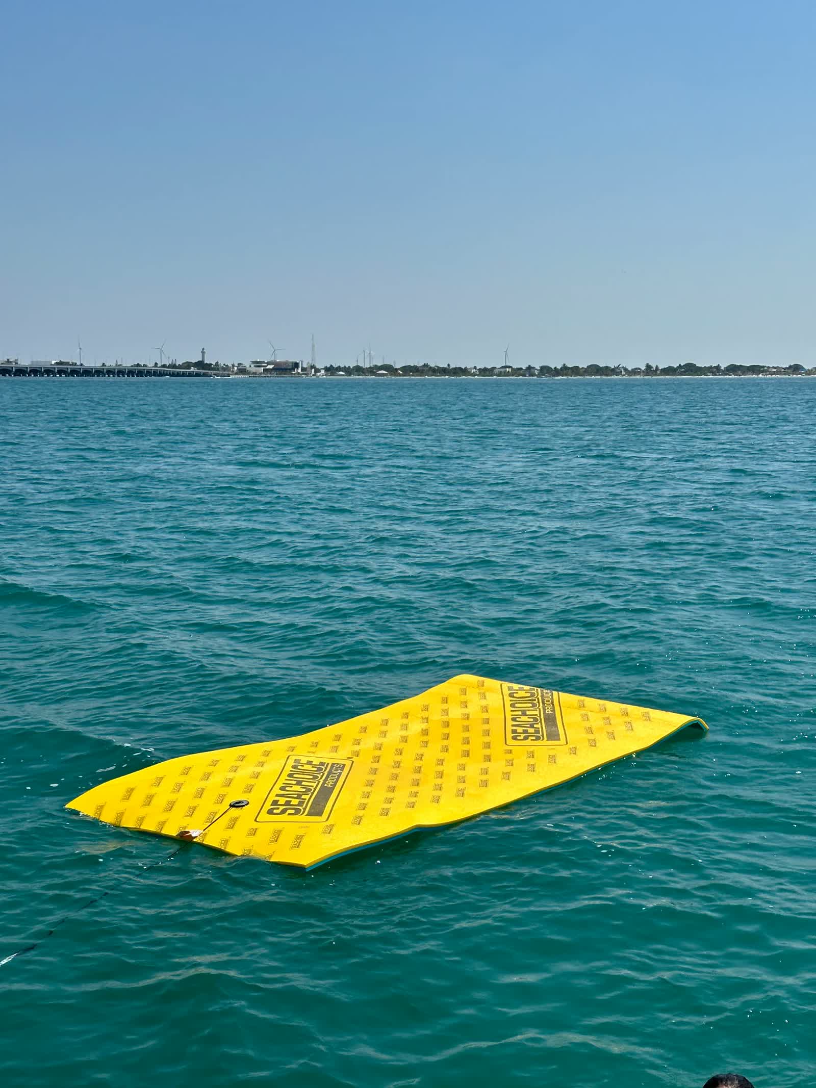Tapete flotante en agua turquesa junto al yate